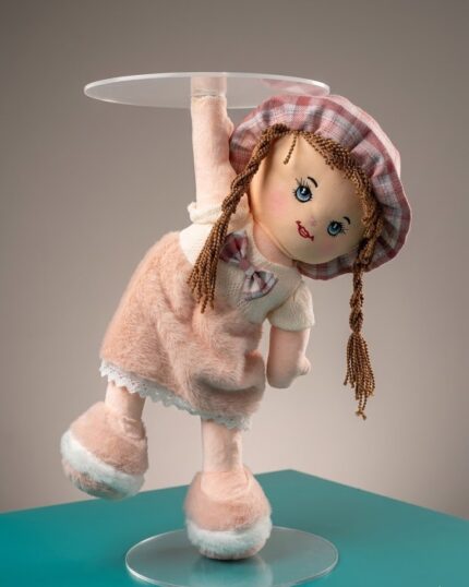 Vedant Enterprises plush doll cake stand with clear acrylic floating platform and pink dressed doll for girls' birthday cake display.